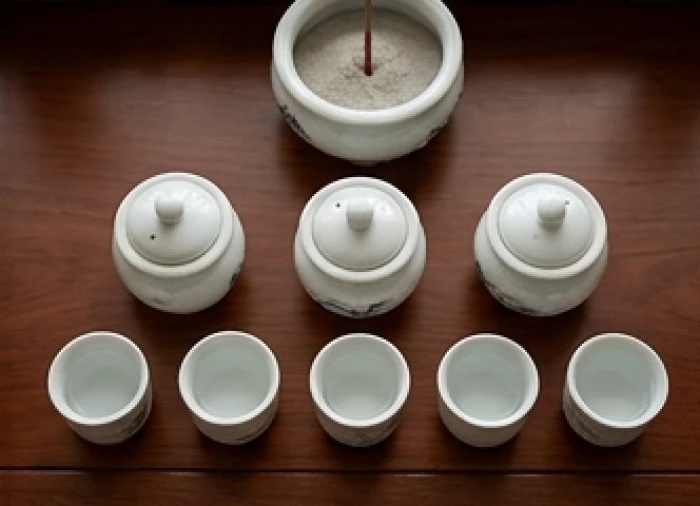 Cách sắp xếp bát hương sứ trắng cùng ngai chén nước cân đối trước tượng Thần Tài và Thổ Địa trên kệ thờ nhỏ