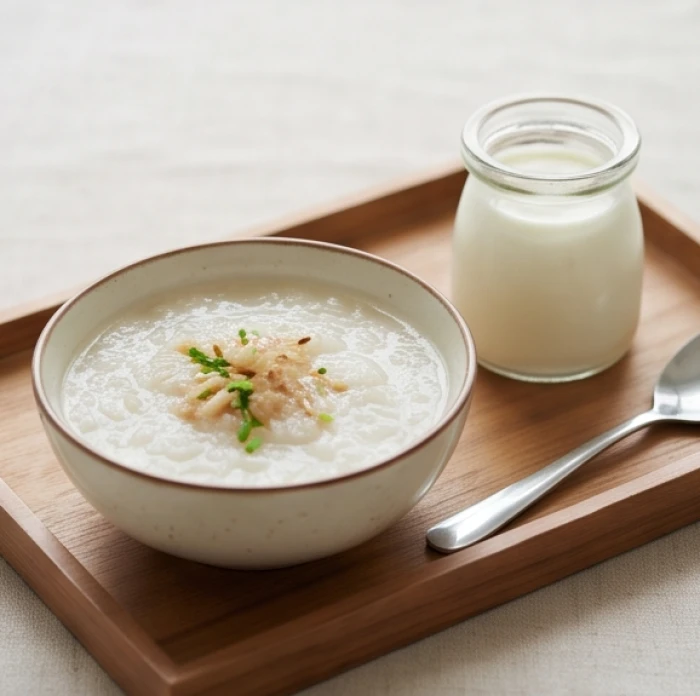 Khay thức ăn dinh dưỡng với chén cháo ấm nóng và một hũ sữa chua được chuẩn bị chu đáo cho bữa ăn phụ