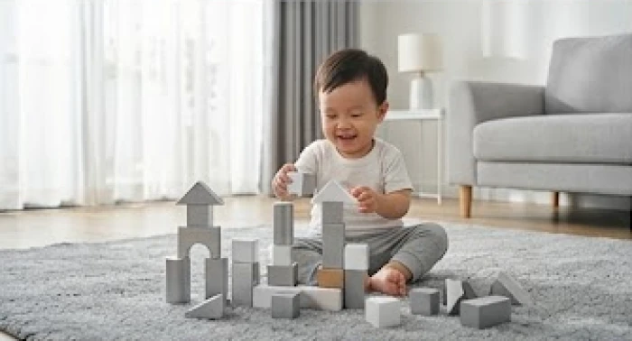 Em bé đang vui chơi trong căn phòng có nhiều đồ vật trang trí mang màu trắng và xám thuộc hành Kim