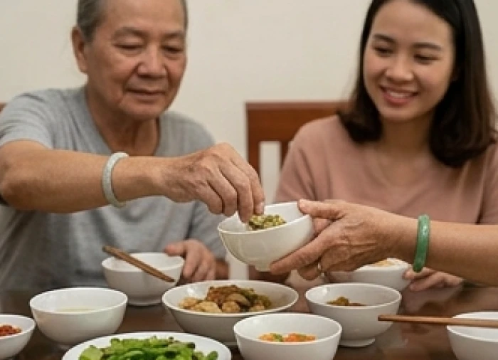 Bữa cơm gia đình quây quần ấm áp nơi người lớn tuổi nhẹ nhàng gắp thức ăn cho con cháu bằng ánh mắt bao dung