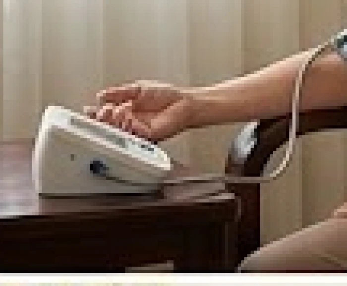Người phụ nữ lớn tuổi đang đo huyết áp tại nhà để theo dõi sức khỏe hàng ngày