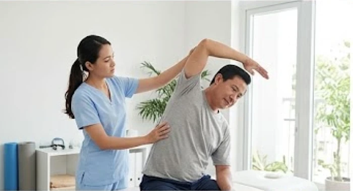 Bác sĩ vật lý trị liệu đang hướng dẫn người đàn ông trung niên tập các bài giãn cơ giảm đau nhức