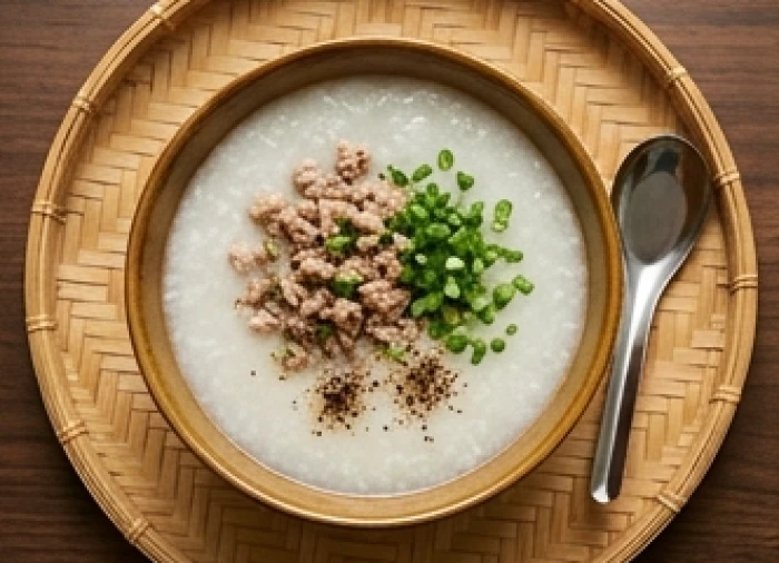 Bát cháo sườn băm nóng hổi rắc thêm chút hành lá và tiêu xúp được đặt gọn gàng trên khay ăn bằng gỗ