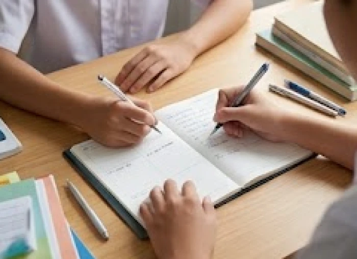 Học sinh ghi chép các con số hợp mệnh 2, 5, 6, 7, 8 vào sổ tay cá nhân trên bàn học