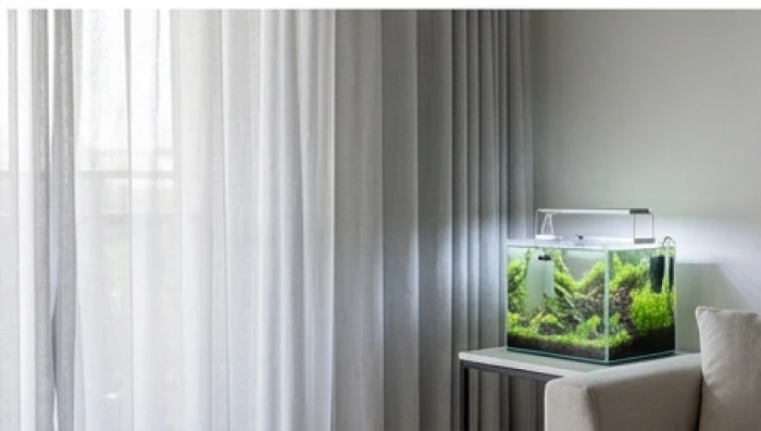 Không gian phòng khách trang nhã với rèm cửa màu xám bạc và bể cá cảnh nhỏ sinh động