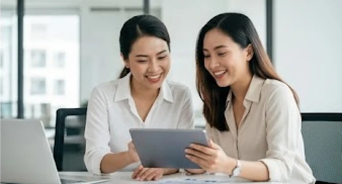 Hai người phụ nữ thảo luận công việc vui vẻ thể hiện sự hợp tác làm ăn ăn ý và phát triển bền vững