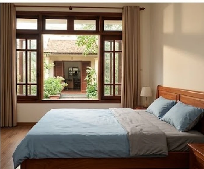 Không gian phòng ngủ hợp phong thủy cho nam mạng Nhâm Thìn với chăn ga màu xanh dương nhẹ nhàng và cửa sổ đón gió Bắc