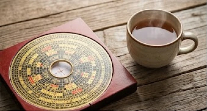 La bàn phong thủy Bát Trạch đặt trên bàn gỗ thể hiện chi tiết các hướng tốt lành cho gia chủ Ất Mùi