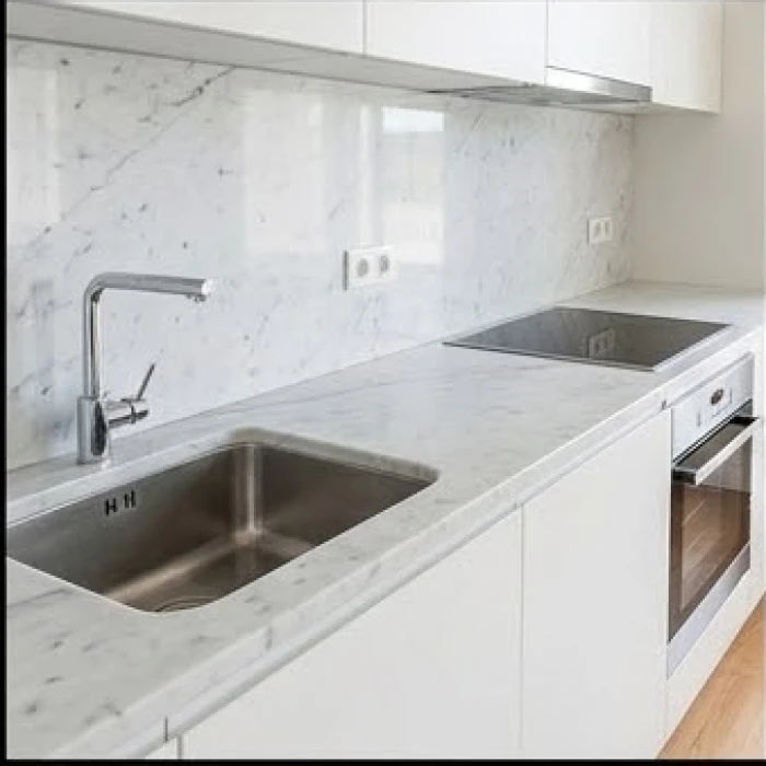 Không gian bàn bếp bằng đá cẩm thạch với chậu rửa và bếp nấu được bố trí cách xa nhau an toàn