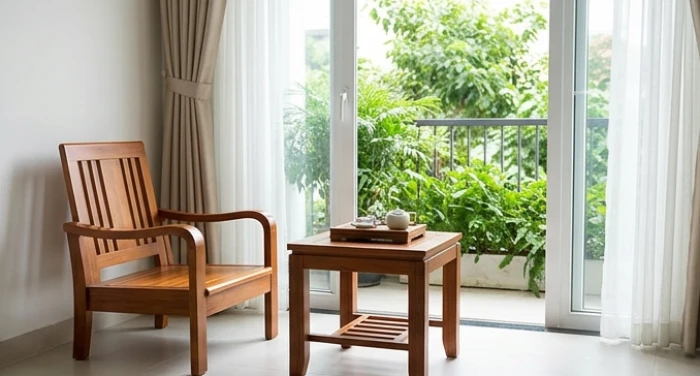 Góc trà thư giãn thoáng đãng hướng ra ban công xanh mát trong phòng khách dành cho người cao tuổi