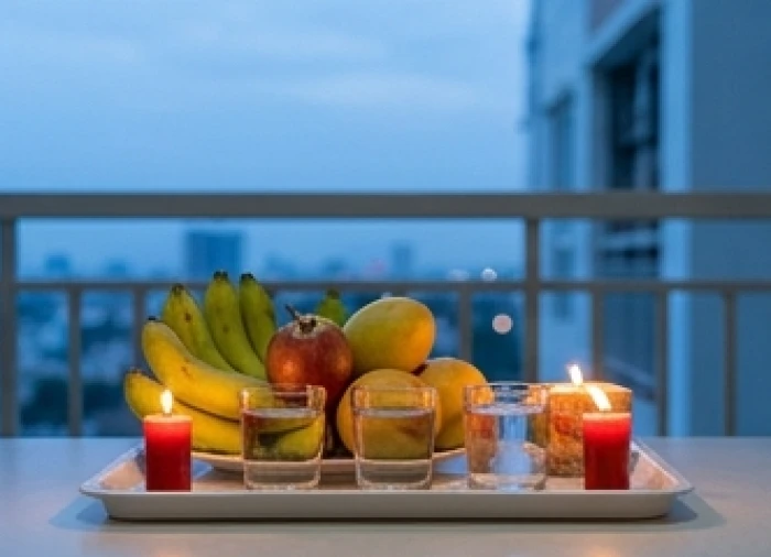 Mâm cúng bình an tinh gọn đặt tại ban công thoáng đãng gồm nến đỏ, hoa quả tươi và nước sạch
