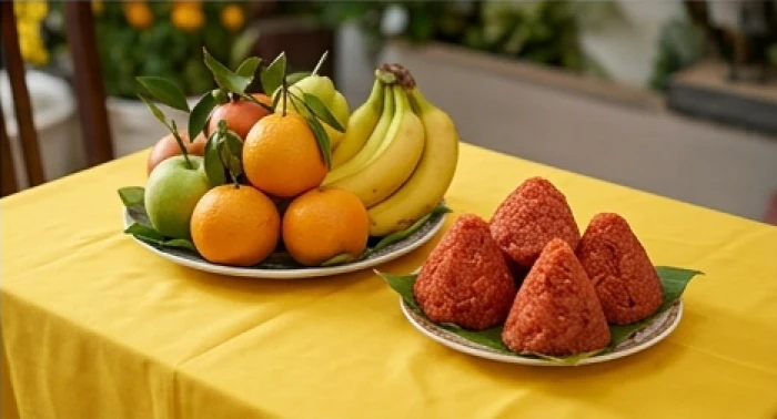 Đĩa trái cây tươi đặt trên tấm vải vàng cùng oản đỏ chuẩn bị cho lễ cúng Kế Đô