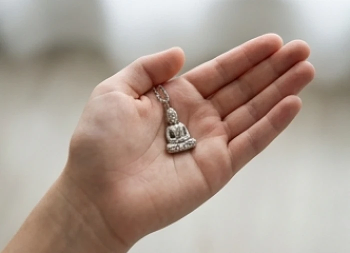 Mặt dây chuyền Phật bản mệnh Đại Thế Chí Bồ Tát làm từ bạc nguyên chất đặt trên lòng bàn tay