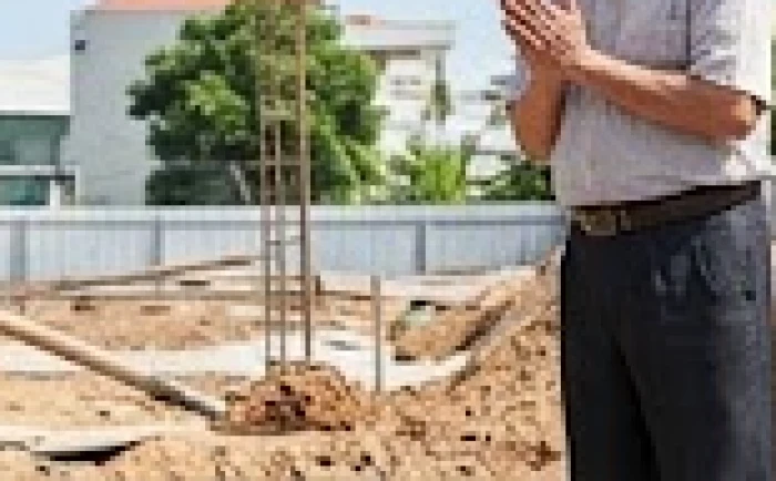Gia chủ lớn tuổi cùng người đàn ông trẻ tuổi hơn đang thực hiện nghi thức động thổ