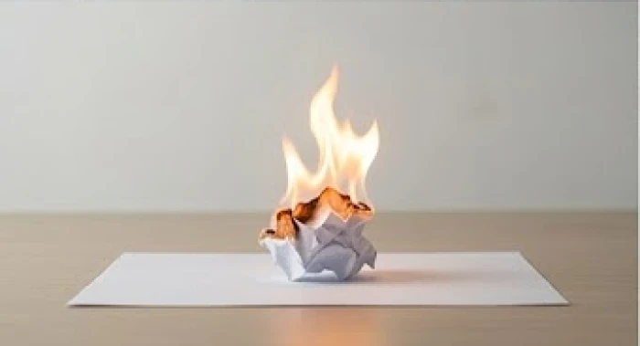 Ngọn lửa nhỏ bùng phát trên một tờ hợp đồng giấy tượng trưng cho sự nóng nảy phá hỏng công việc đàm phán