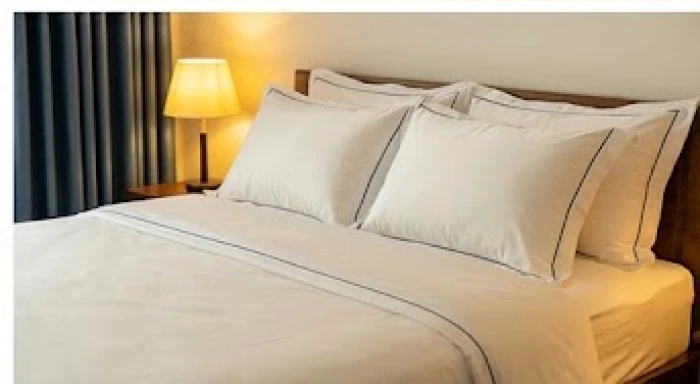 Bộ chăn ga gối đệm phối màu trắng ngà và điểm xuyết viền xanh dương mang lại cảm giác ấm áp
