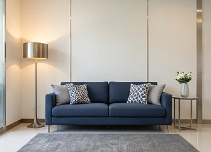Phòng khách phối tường trắng xám và sofa xanh navy kết hợp đèn ấm cho gia chủ tuổi Ất Mão 1975