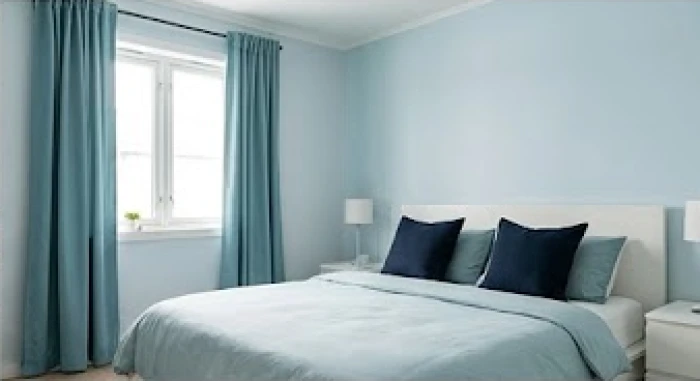 Phòng ngủ hiện đại áp dụng tỷ lệ 60-30-10 với tường xanh pastel, rèm xanh ngọc và gối tựa màu lam thẫm