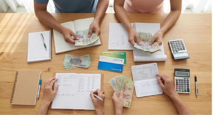 Hai vợ chồng cùng nhau phân chia các khoản chi tiêu và lập quỹ dự phòng bằng tiền mặt và sổ tiết kiệm