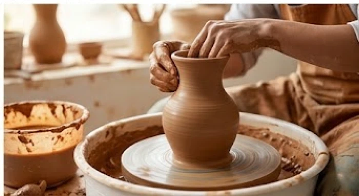 Bàn tay thợ gốm đang nắn nót tạo hình sản phẩm trên bàn xoay thể hiện sự tỉ mỉ đặc trưng