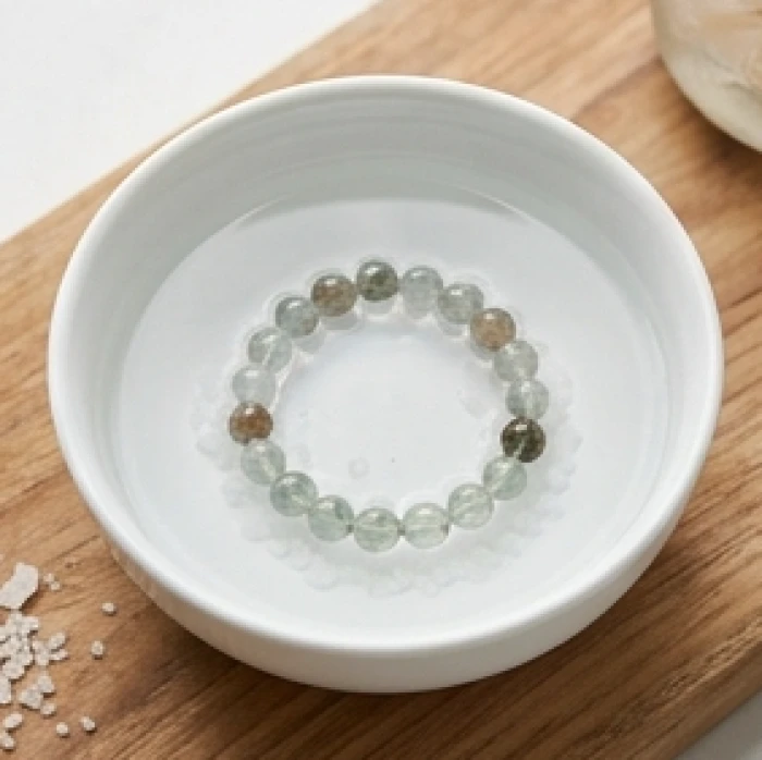 Chiếc vòng đá tự nhiên ngâm trong bát sứ trắng chứa dung dịch nước muối pha loãng để thanh tẩy