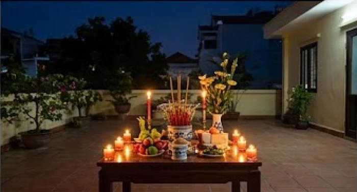 Gia chủ thành tâm thắp nến và dâng hương trên bàn thờ ngoài trời lúc ban đêm để làm lễ giải hạn sao chiếu mệnh