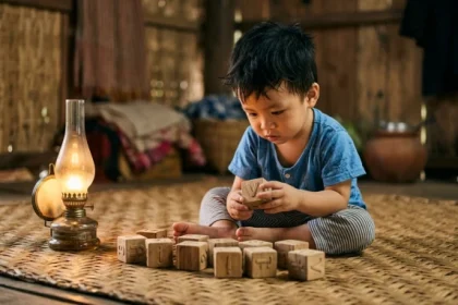 Em bé Việt Nam đang quan sát đồ chơi xếp hình thể hiện rõ tính cách tuổi ất tỵ 2025 mệnh Hỏa