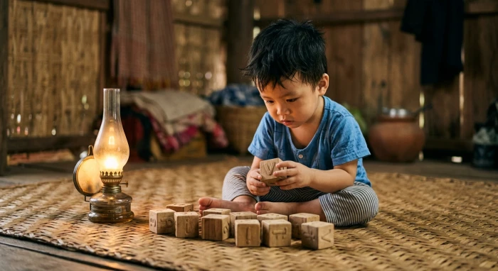 Em bé Việt Nam đang quan sát đồ chơi xếp hình thể hiện rõ tính cách tuổi ất tỵ 2025 mệnh Hỏa