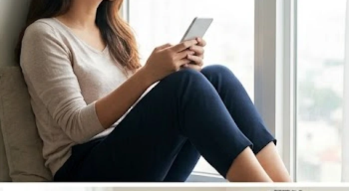 Người phụ nữ cầm điện thoại với vẻ mặt trầm ngâm đang suy nghĩ về mối quan hệ tình cảm cá nhân