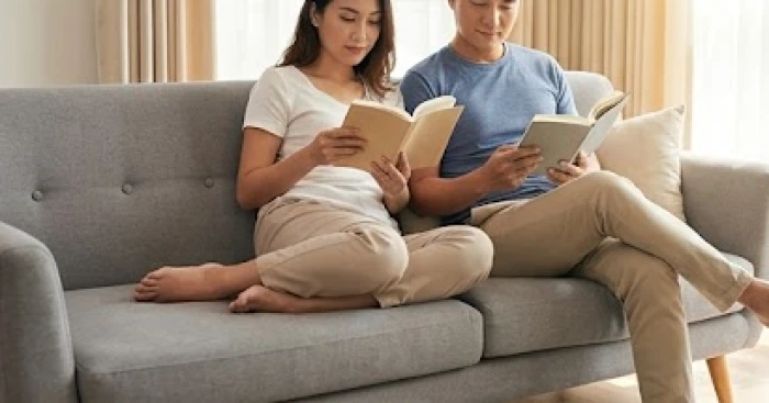 Cặp đôi ngồi cách nhau một khoảng vừa phải trên sofa thể hiện sự tôn trọng không gian riêng tư