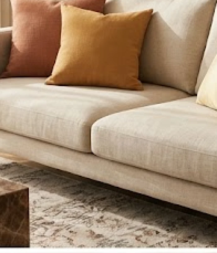 Ghế sofa êm ái được trang trí thêm những chiếc gối tựa màu nâu đất và vàng kem để điều hòa không gian