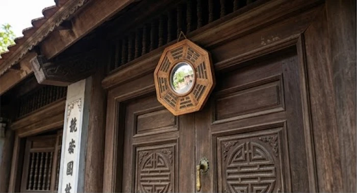 Gương bát quái lồi treo chính giữa mép trên khung cửa chính ngôi nhà