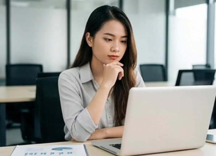 Nữ nhân viên văn phòng đang suy nghĩ cẩn trọng khi phân tích dữ liệu trên màn hình