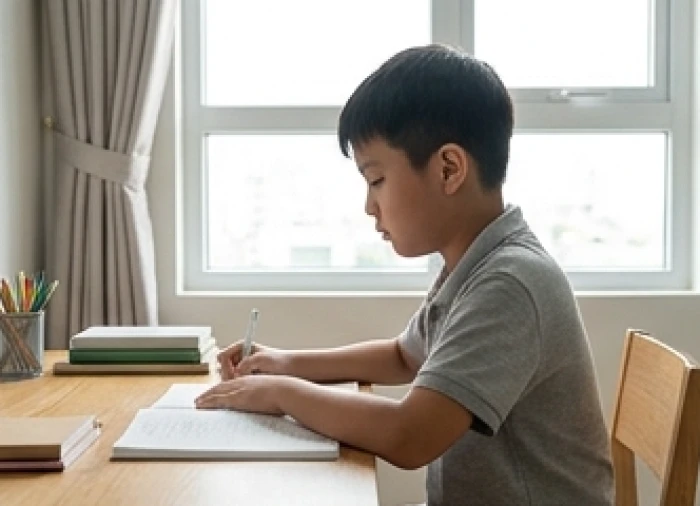 Trẻ ngồi học với tư thế thẳng lưng và giữ khoảng cách an toàn từ mắt đến trang sách