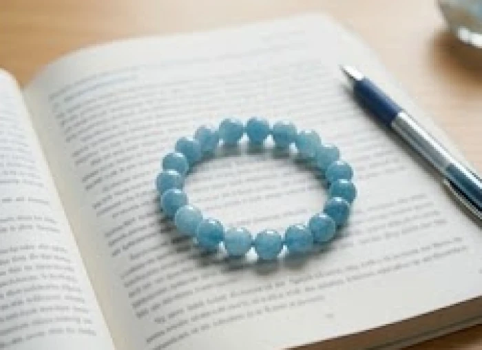 Vòng tay đá tự nhiên Aquamarine xanh dương đặt cạnh sách vở giúp cân bằng năng lượng cho học sinh
