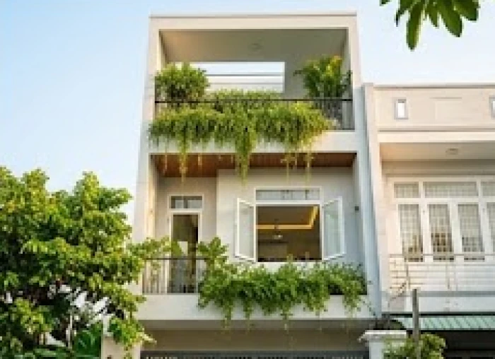 Ngôi nhà phố hiện đại ba tầng khang trang với nhiều cây xanh và ánh sáng rực rỡ tượng trưng cho sự thịnh vượng