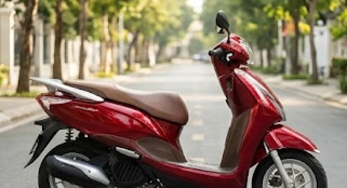 Chiếc xe tay ga màu đỏ ruby bóng bẩy với phần yên da màu nâu ấm áp dựng dưới ánh nắng ban mai rực rỡ